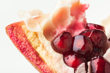 Macro shot of ripe pomegranate fruit on white background. Ripe pomegranate cracked in a half with...