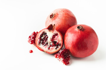 Whole and half of fresh pomegranate fruit isolated on white background. Ripe pomegranates cracked...