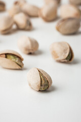 Close up of pistachio nut seeds in shells isolated on the white background. Salted dried beer snack. Macro shot