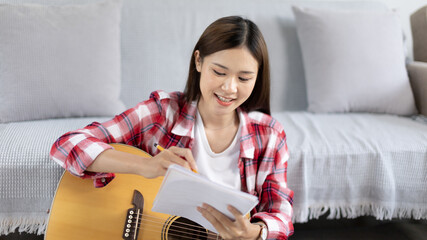 Asian woman specializes in music is composing the lyrics and melody for the opening of a new...