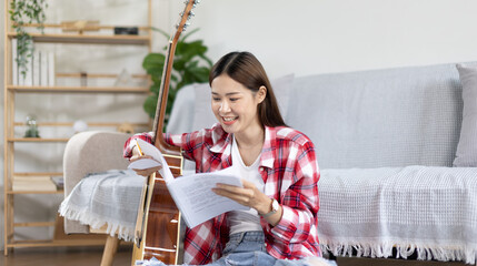 Asian woman specializes in music is composing the lyrics and melody for the opening of a new...