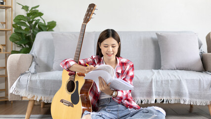 Asian woman specializes in music is composing the lyrics and melody for the opening of a new...
