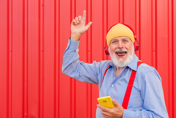 a modern retiree listening to music with headphones and dancing
