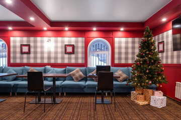 Christmas tree with gifts in dining room of guest house interior design