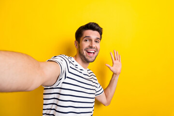 Photo of friendly glad person toothy smile make selfie arm palm waving hi isolated on yellow color background