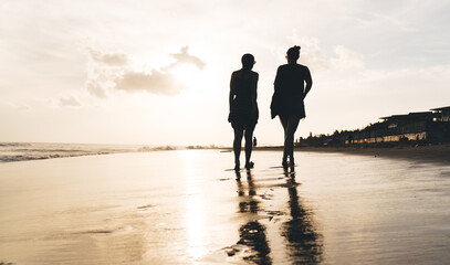 Fototapeta na wymiar Silhouette of friends walking along beach