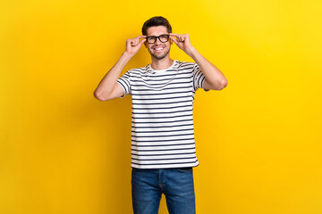 Photo of cheerful nice person beaming smile hands touch glasses isolated on yellow color background