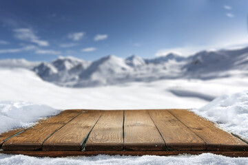 Wooden desk cover of snow flakes and winter landscape of free space. 