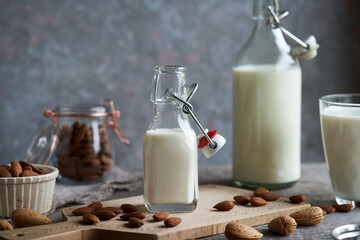 A bottle of vegan almond milk with whole and shelled almonds