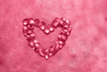 Heart of rose petals in viva magenta color. Valentine's Day. Top view, flat lay. Trending color of 2023 - Viva Magenta.