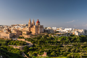 Fototapeta na wymiar Il-Mellieha, Malta - Mellieha town at sunny day with Paris Church on hill top