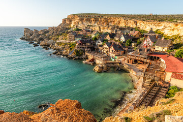 Famous Popeye Village in Anchor Bay, Mellieha, Malta. Turquoise sea water and blue sky. - obrazy, fototapety, plakaty