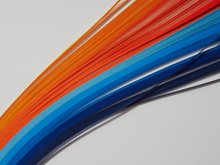 Rainbow colored quilling paper laid out in waves and shapes