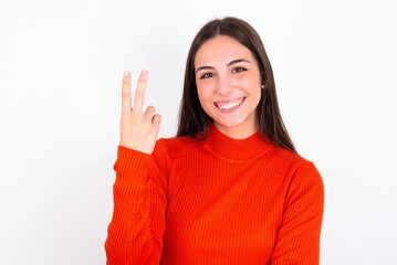 Young caucasian woman wearing red sweater over white background smiling and looking friendly, showing number two or second with hand forward, counting down