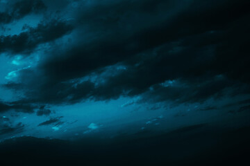 Naklejka na ściany i meble Black green blue night sky with clouds. Dark dramatic skies background for design. Cloudy, rainy, windy, stormy weather. Or a frightening, spooky, creepy, nightmare concept.