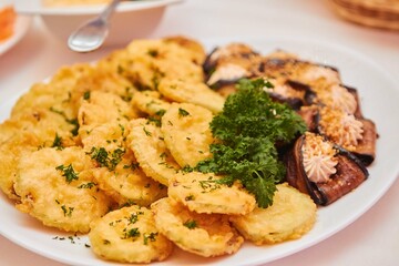 Baked fast food, nuggets and potatoes with vegetables on a plate.