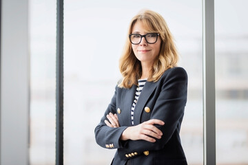Executive caucasian businesswoman wearing eyewear and blazer while standing at the office - 551576108