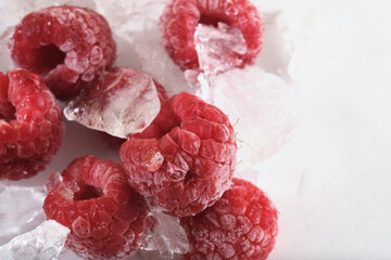 Freeze dried raspberries closeup with ice on white background.