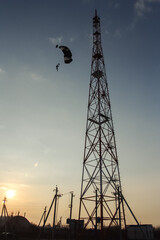 skydiver jumping from a metal tower at dawn