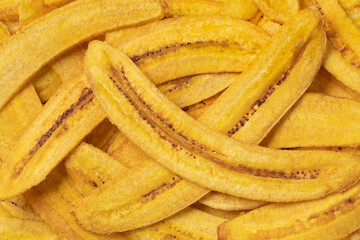 Fresh baked banana chips close up full frame as background