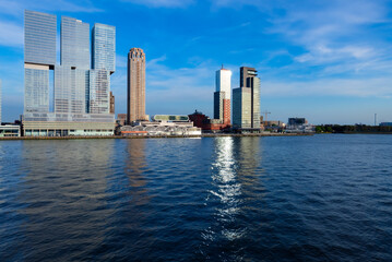 Rotterdam waterfront panorama from “Erasmus-Bridge“ over river Nieuwe Maas on a blue sky day in South Holland Netherlands. Tall office buildings, cruise terminal near major sea port with reflection.