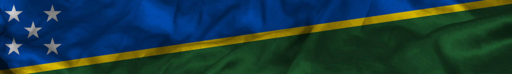 Elongated national flag of Solomon Islands with a fabric texture fluttering in the wind. Solomon Islands flag for website design. 3d illustration