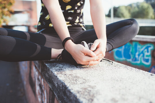 Cropped woman in black sportswear doing gymnastic and stretching outdoors