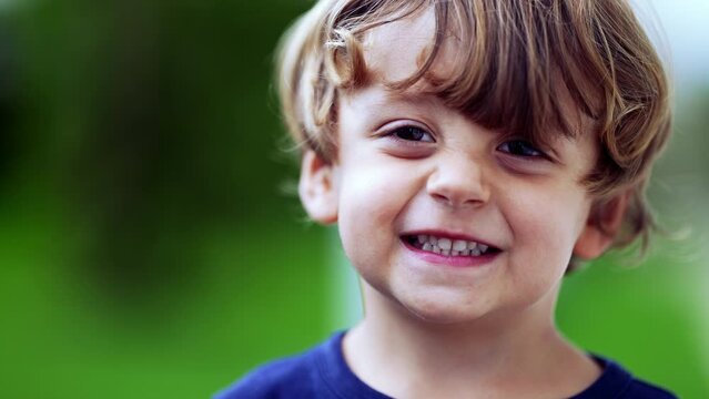 Fun cute little boy portrait face standing outside grimaces