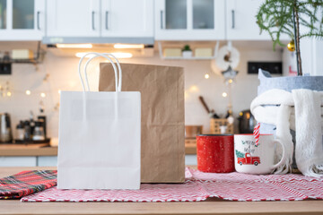 Food delivery service containers on table white scandi festive kitchen in christmas decor. Eve New year, saving time, too lazy to cook, hot order, disposable plastic box in fairy light. mock up