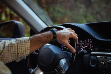 middle aged man driving a car