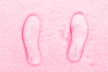 Two shoe tracks in the snow. New Trendy Viva Magenta 2023