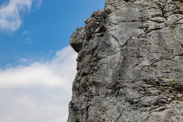 Close-up on a climbing rock, against a blue sky, the road prepared for climbing. visible scratches and holes to facilitate climbing