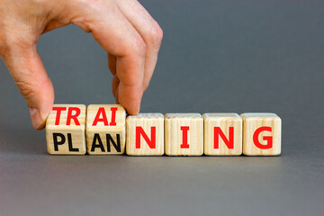 Training and planning symbol. Concept word Training and Planning on wooden cubes. Businessman hand. Beautiful grey table grey background. Business training and planning concept. Copy space.