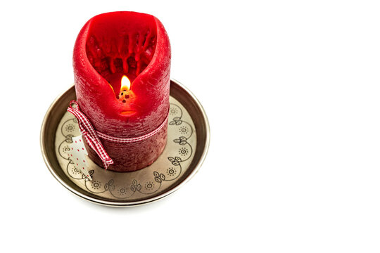 A red candle with a decorated coaster isolated for Christmas