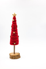 A red decorated Christmas tree made of wood and felt cut out in front of white background