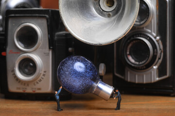Miniature Workmen Handling Vintage Flashbulb and Camera