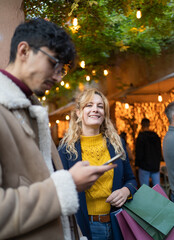 selective focus on smiling Blonde woman looking at after shopping with her boyfriend