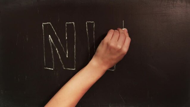 Timelapse of a person hand writes abbreviation NLP on blackboard with white chalk. NLP is written on blackboard with white chalk. Concept of psychology, Neuro-linguistic programming
