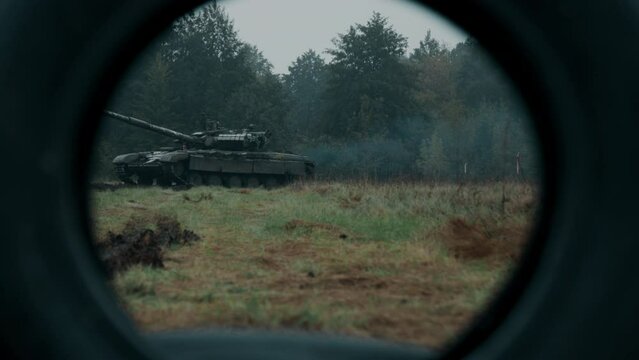 Drives Ukraine tank T-72 through a frame made of tires on the battlefield. Focusing. Armed forces of Ukraine.