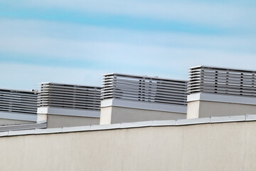 House outdoor roof ventilation on sunny day on blue sky background.  Air conditioner system set on...