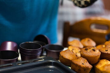 Cupcakes with raisins just from oven, taking off from cupcakes cutters. 