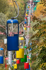 Fototapeta na wymiar Cableway transport cabins in Kharkiv city center park with autumn colored trees