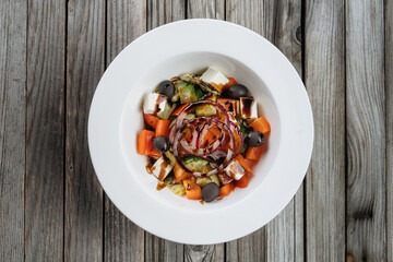 Greek salad with fresh vegetables, feta cheese and black olives.