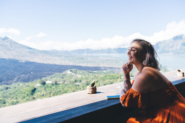 Cheerful woman enjoying view of mountains on terrace