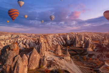 Beautiful sunset landscape group horse riding tour with hot air balloons in Cappadocia autumn Turkey valley from aerial view