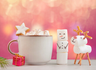 Christmas mug with hot chocolate, marshmallows and red gift box. handmade marshmallow snowman and christmas deer. christmas festive banner with viva magenta glittering background, copy space for text.