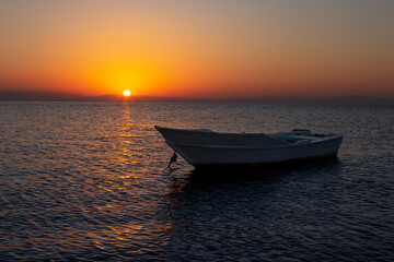 Colorful sunrise seascape with a fisherman boat in the foreground, Dahab, Sinai, Egypt