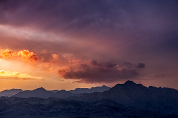 Fototapeta premium Dramatic colorful clouds over mountains at sunset, Dahab, Egypt