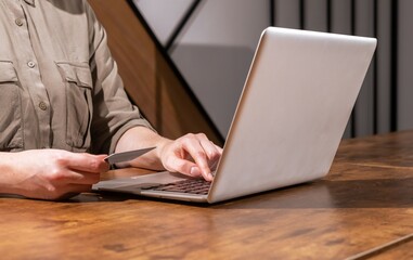 Paying with bank debit card through internet, shopping online with laptop computer, buying virtually. Virtual payment concept