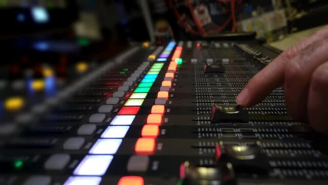 Close-up shot of audio mixer. Voice technician working on music mixer desk.